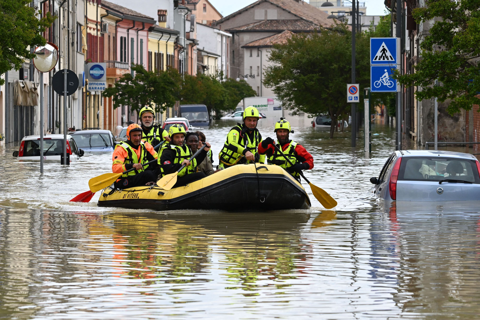 Rescuers evacuate residents in a dinghy across a flooded street in the town of Lugo on May 18, 2023, after heavy rains caused flooding across Italy's northern Emilia Romagna region, killing nine people. (Photo by Andreas SOLARO / AFP) (Photo by ANDREAS SOLARO/AFP via Getty Images)